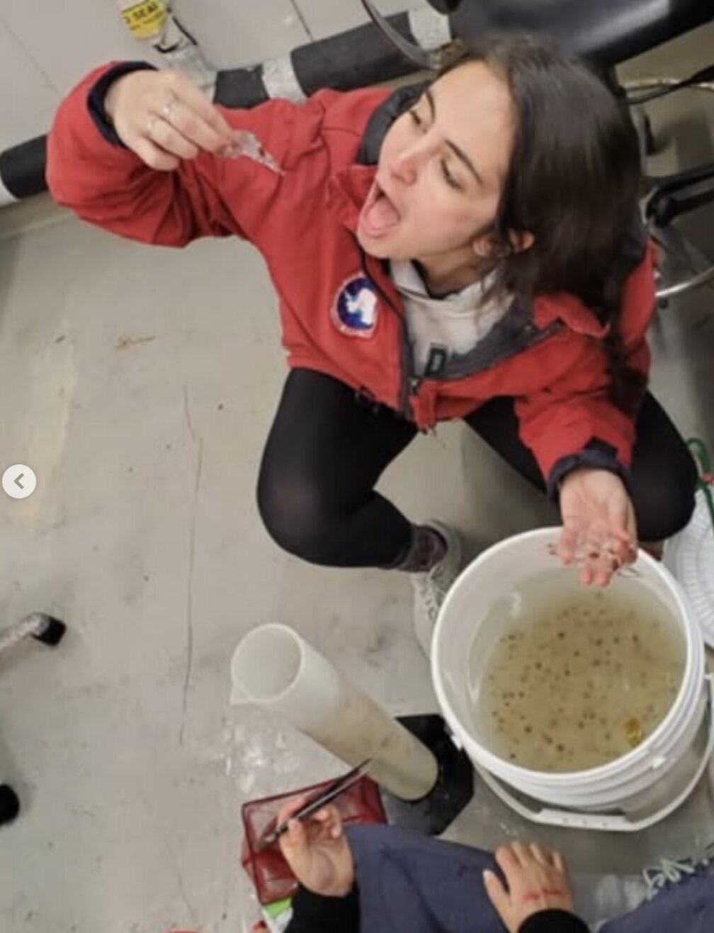 Jacquelyn Veatch playfully inspecting a small marine organism during sample processing