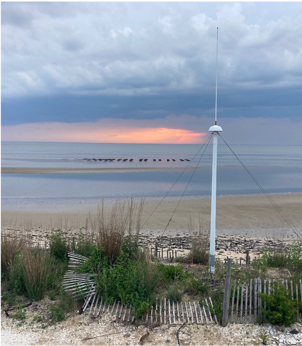 A high-frequency radar antenna overlooking the ocean at sunset