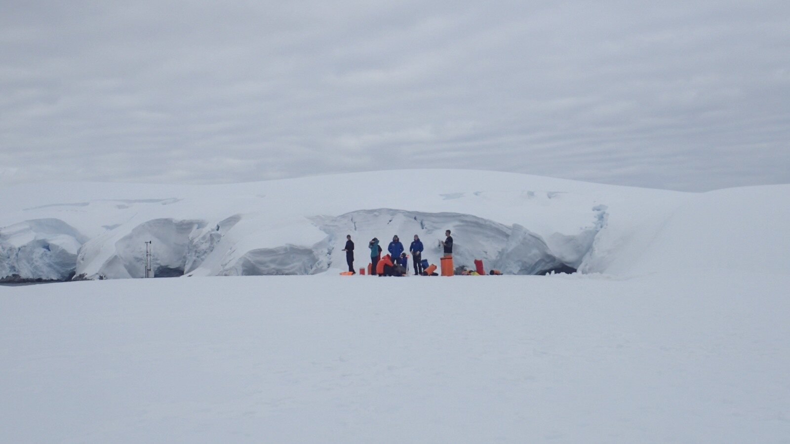 A research team working with ocean-observing equipment on the snow near Palmer Station, Antarctica